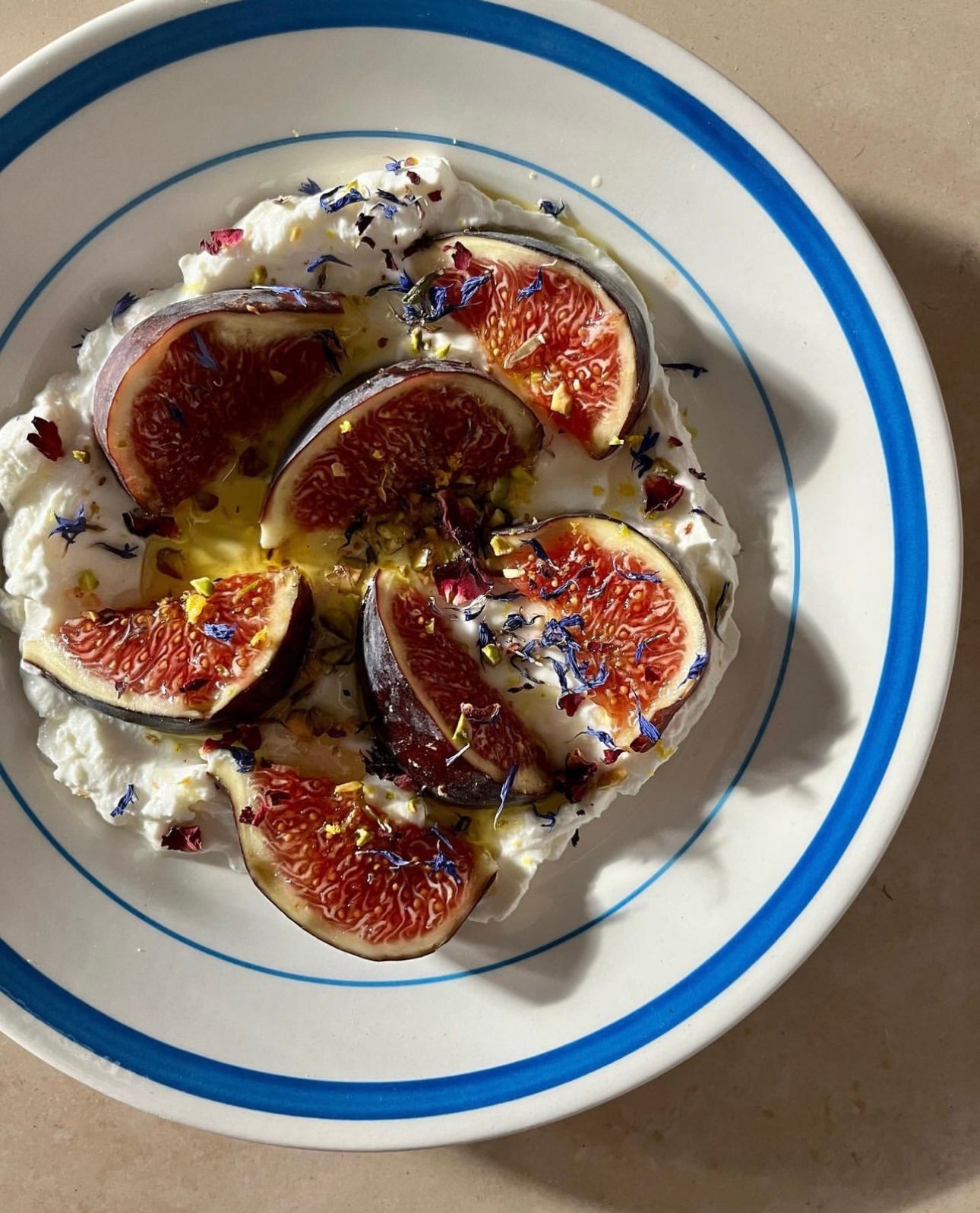 Figs served on labneh with honey, olive oil, and pistachio.