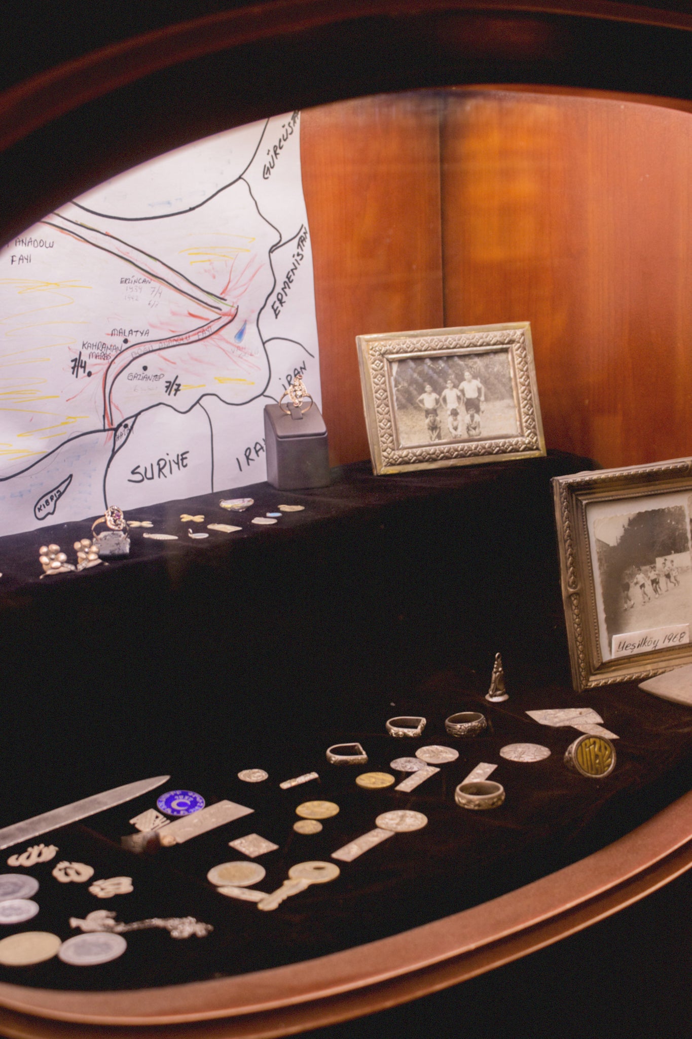 A vitrine of family heirlooms and stories, silver rings, and odds and ends. 
