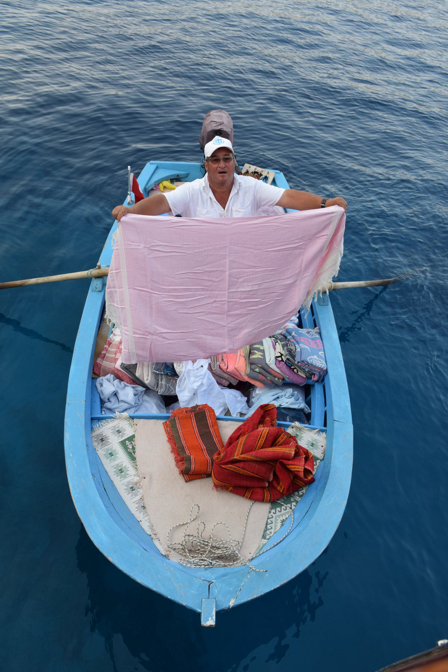 Hasan, who sells woven textiles, Turkish towels and simple summer dresses in Serce Cove.